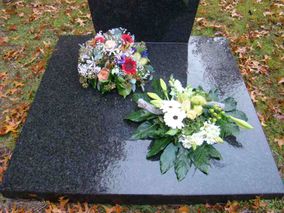 Graf met twee mooie bloemstukken